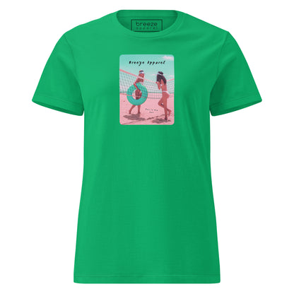 Irish-green t-shirt with an image of two women in bikinis on the beach, standing by a volleyball net, one holding a swim ring and smiling, the other leaning on the net, with inscription in black of 'breeze apparel' towards the top of the image, and 'fun in the sun' in black on the ground between the women. 