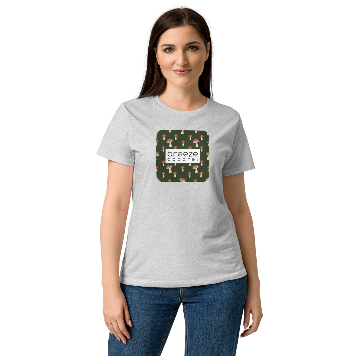 Woman wearing gray t-shirt with graphic of mushroom pattern set on a green background, overlaid with a white box with 'breeze apparel' in black inside.
