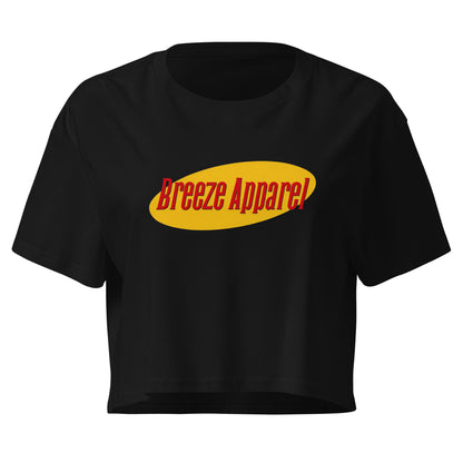 Black crop top with graphic with red lettering set on a yellow oval. 