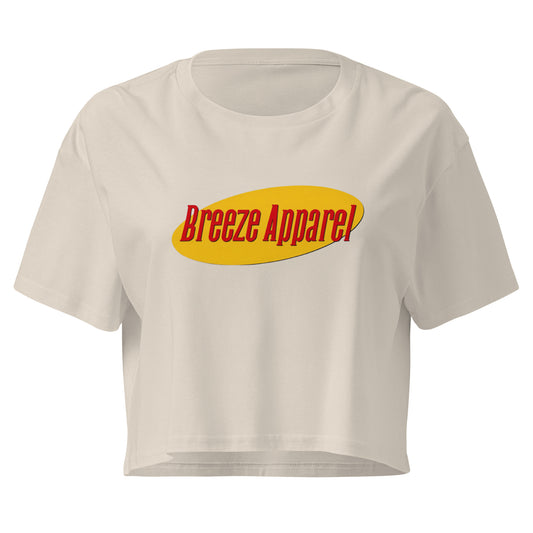 Cream crop top with graphic with red lettering set on a yellow oval. 