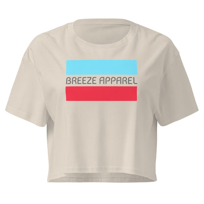Cream crop top with graphic of gray lettering between blue and red horizontal bars.