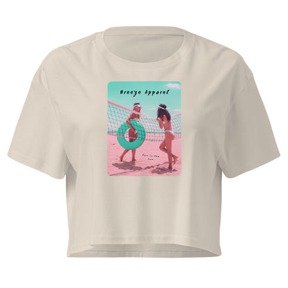 Cream crop top with graphic of two women in bikinis talking on the beach.