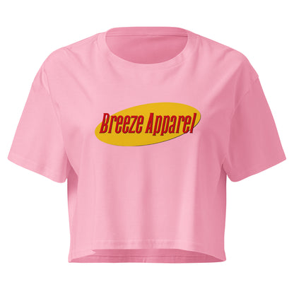 Pink crop top with graphic with red lettering set on a yellow oval. 