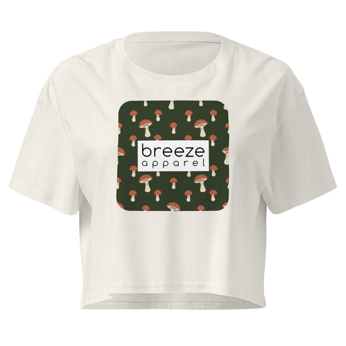 Cream crop top with graphic of mushrooms set on a green background and overlaid with a white rectangle logo.