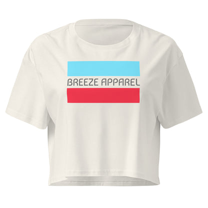 Cream crop top with graphic of gray lettering between blue and red horizontal bars.