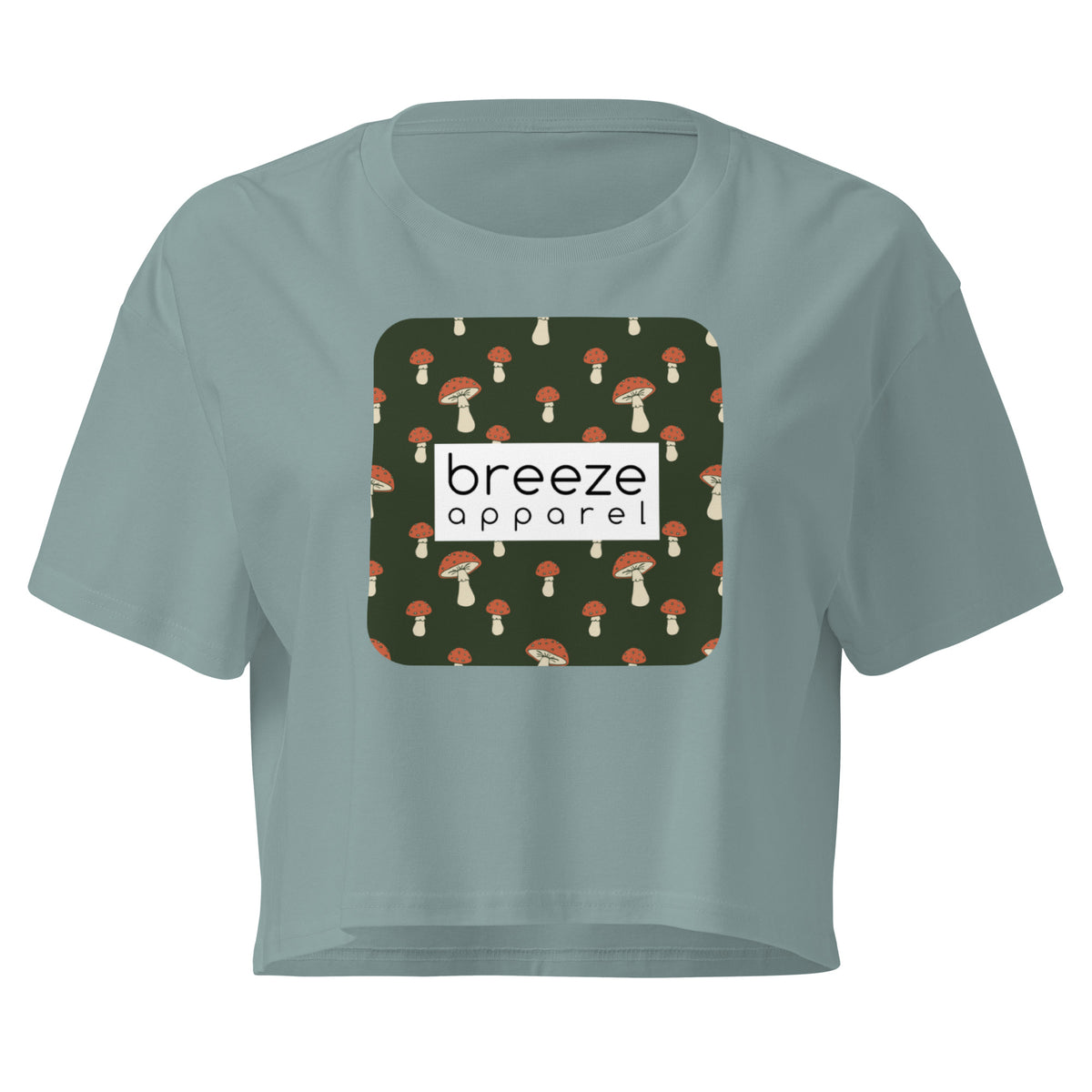 Green crop top with graphic of mushrooms set on a green background and overlaid with a white rectangle logo.