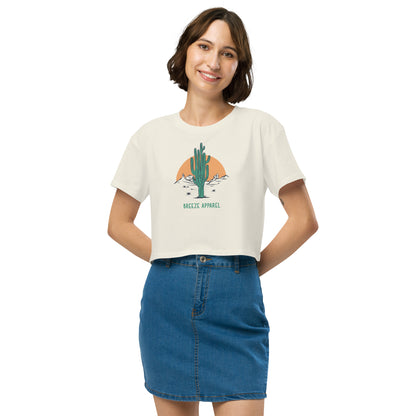 Woman wearing cream crop top with cactus graphic.