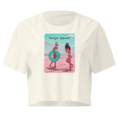 Cream crop top with graphic of two women in bikinis talking on the beach.
