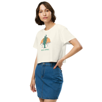 Woman wearing cream crop top with cactus graphic.