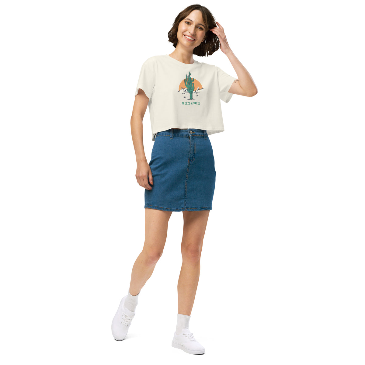 Woman wearing cream crop top with cactus graphic.