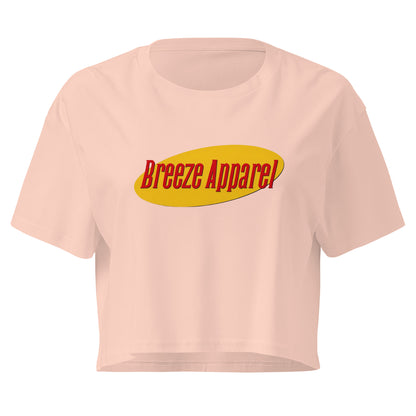 Pink crop top with graphic with red lettering set on a yellow oval. 