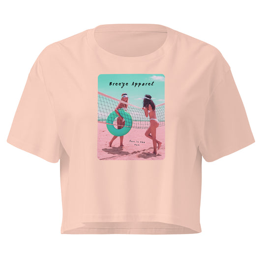 Pink crop top with graphic of two women in bikinis talking on the beach.