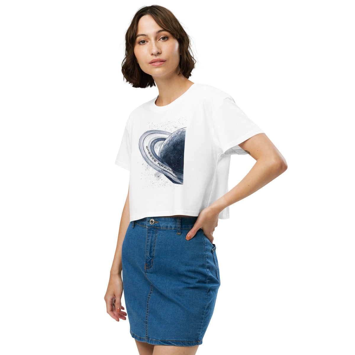 Woman wearing white crop top with graphic of blue planet.