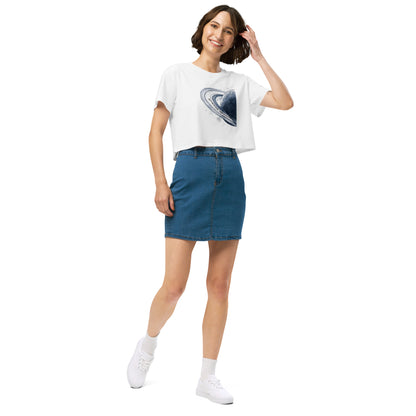 Woman wearing white crop top with graphic of blue planet.