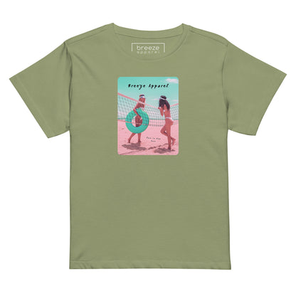 Artichoke-green t-shirt with an image of two women in bikinis on the beach, standing by a volleyball net, one holding a swim ring and smiling, the other leaning on the net, with inscription in black of 'breeze apparel' towards the top of the image, and 'fun in the sun' in black on the ground between the women. 