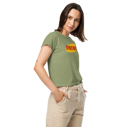 Woman wearing green t-shirt with red lettering over yellow oval.