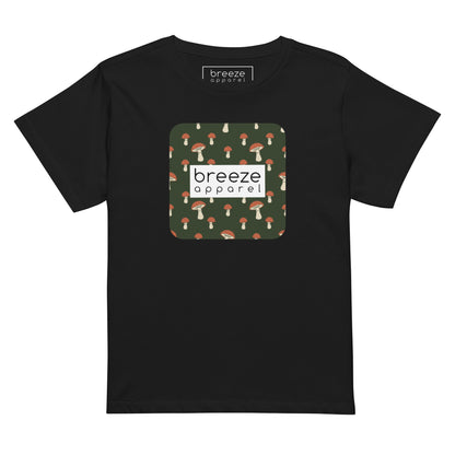 Black t-shirt with design of mushrooms set on green background and overlaid with a white rectangle with 'breeze apparel' in black inside.