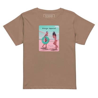 Latte t-shirt with an image of two women in bikinis on the beach, standing by a volleyball net, one holding a swim ring and smiling, the other leaning on the net, with inscription in black of 'breeze apparel' towards the top of the image, and 'fun in the sun' in black on the ground between the women. 