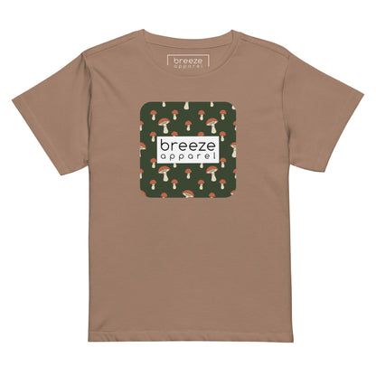 Brown t-shirt with design of mushrooms set on green background and overlaid with a white rectangle with 'breeze apparel' in black inside.
