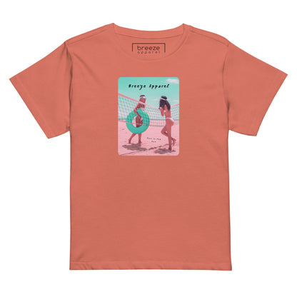 Red-sorbet t-shirt with an image of two women in bikinis on the beach, standing by a volleyball net, one holding a swim ring and smiling, the other leaning on the net, with inscription in black of 'breeze apparel' towards the top of the image, and 'fun in the sun' in black on the ground between the women. 