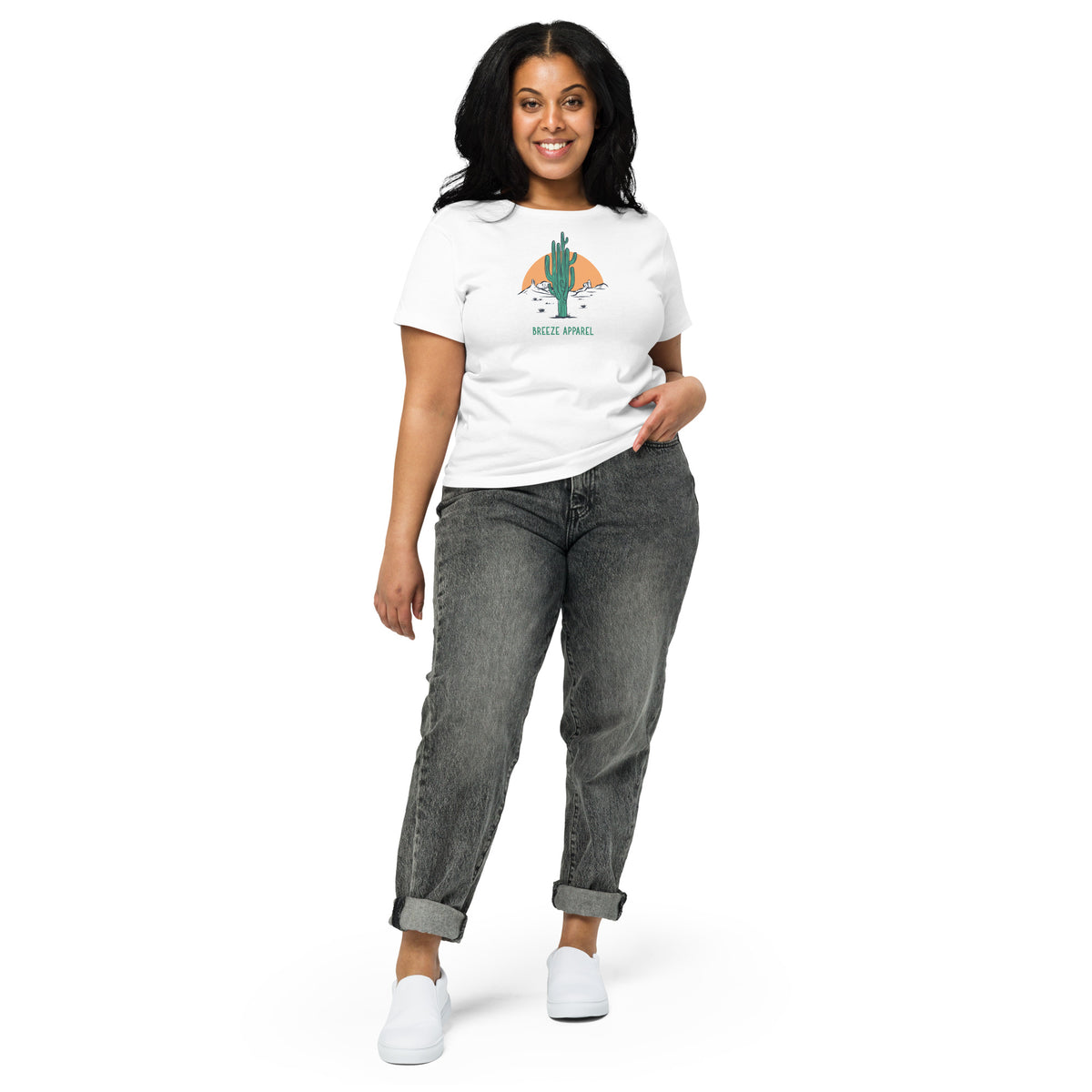 Woman wearing white t-shirt with a graphic of a cactus and sunset, with 'Breeze Apparel' written in green below.