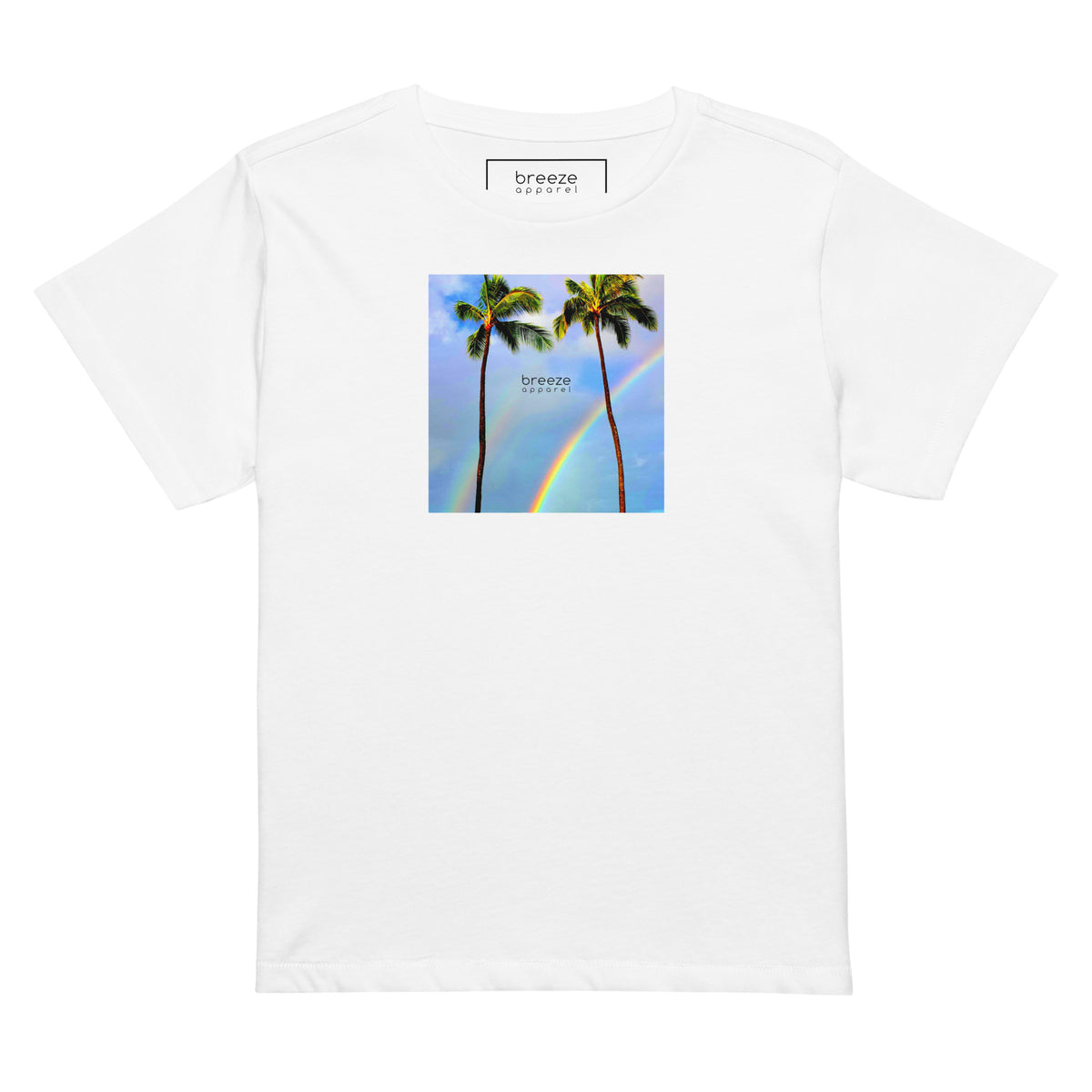 White t-shirt with a graphic of palm trees, rainbow, and a clear blue sky in the background. A small, black 'breeze apparel' logo is between the trees.
