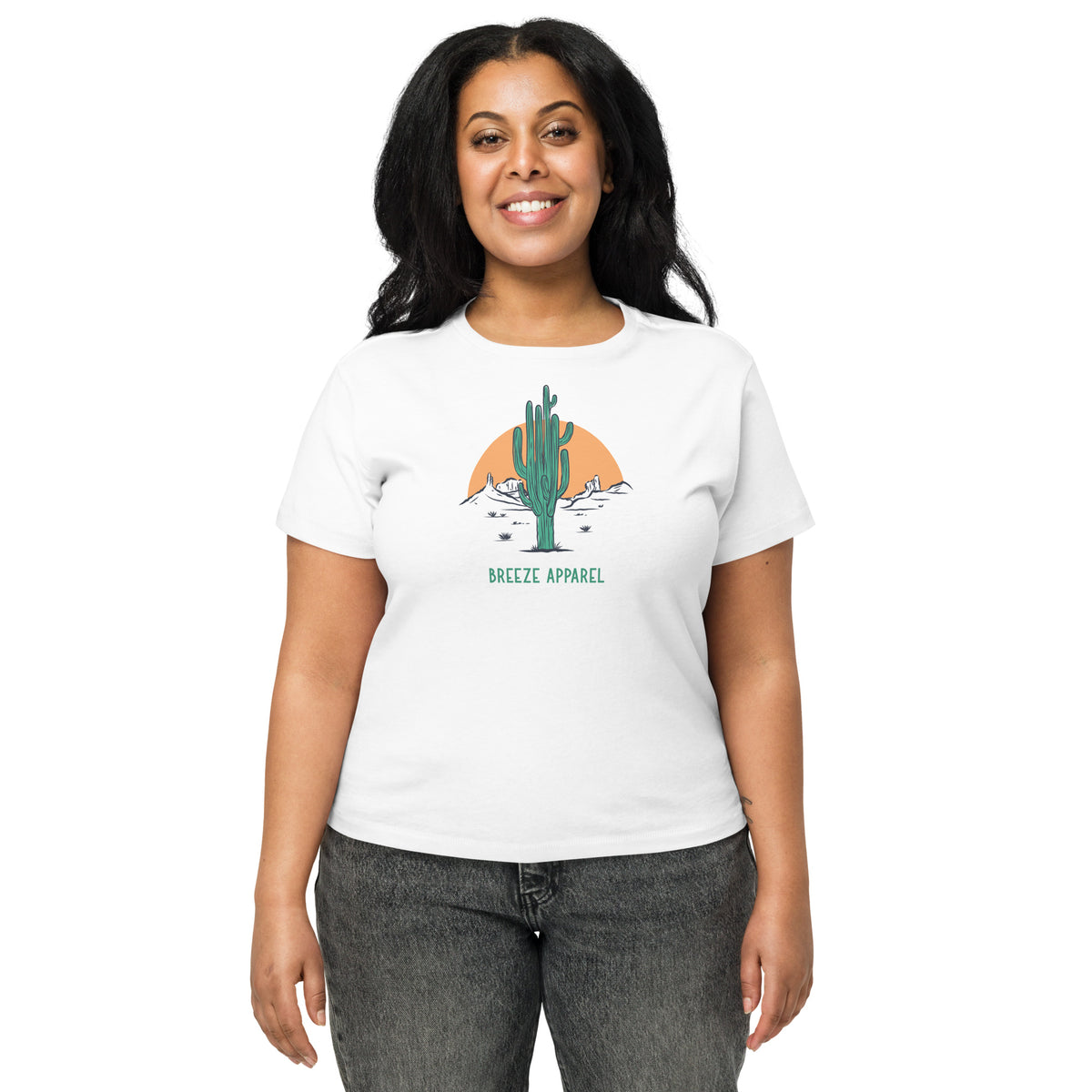 Woman wearing white t-shirt with a graphic of a cactus and sunset, with 'Breeze Apparel' written in green below.