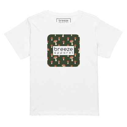 White t-shirt with design of mushrooms set on green background and overlaid with a white rectangle with 'breeze apparel' in black inside.