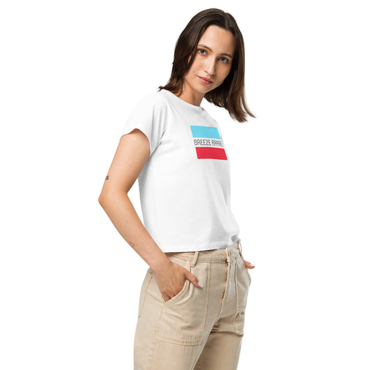 Woman wearing white t-shirt with gray 'Breeze Apparel' logo between horizontal bars, the top being light blue and the bottom being red.