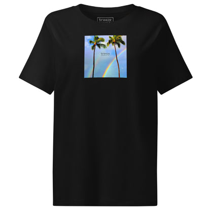 Black t-shirt with a graphic of palm trees, rainbow, and a clear blue sky in the background. A small, black 'breeze apparel' logo is between the trees.