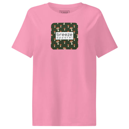 Pink t-shirt with square graphic of mushrooms set on a green background overlaid with a white rectangle in which 'breeze apparel' is in black.