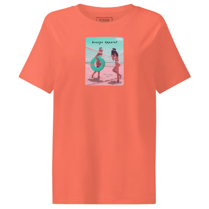 Fiesta-orange t-shirt with an image of two women in bikinis on the beach, standing by a volleyball net, one holding a swim ring and smiling, the other leaning on the net, with inscription in black of 'breeze apparel' towards the top of the image, and 'fun in the sun' in black on the ground between the women. 