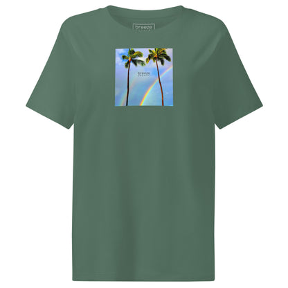 Green t-shirt with a graphic of palm trees, rainbow, and a clear blue sky in the background. A small, black 'breeze apparel' logo is between the trees.
