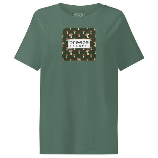 Green t-shirt with square graphic of mushrooms set on a green background overlaid with a white rectangle in which 'breeze apparel' is in black.