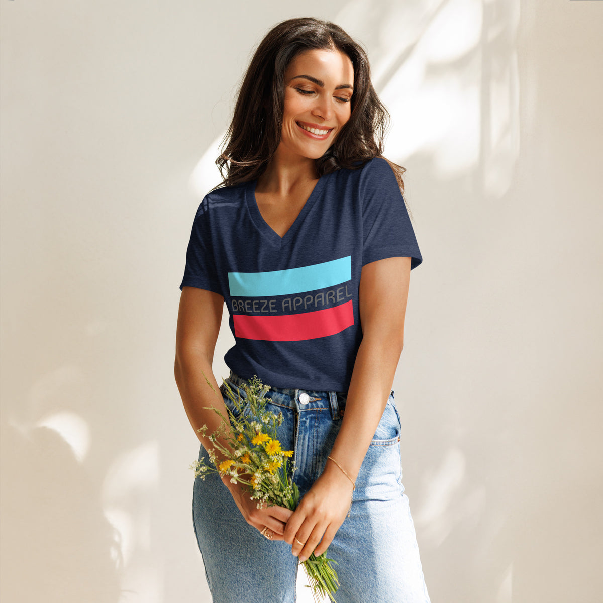 Woman wearing navy v-neck t-shirt with gray 'Breeze Apparel' logo between horizontal bars, the top being light blue and the bottom being red.