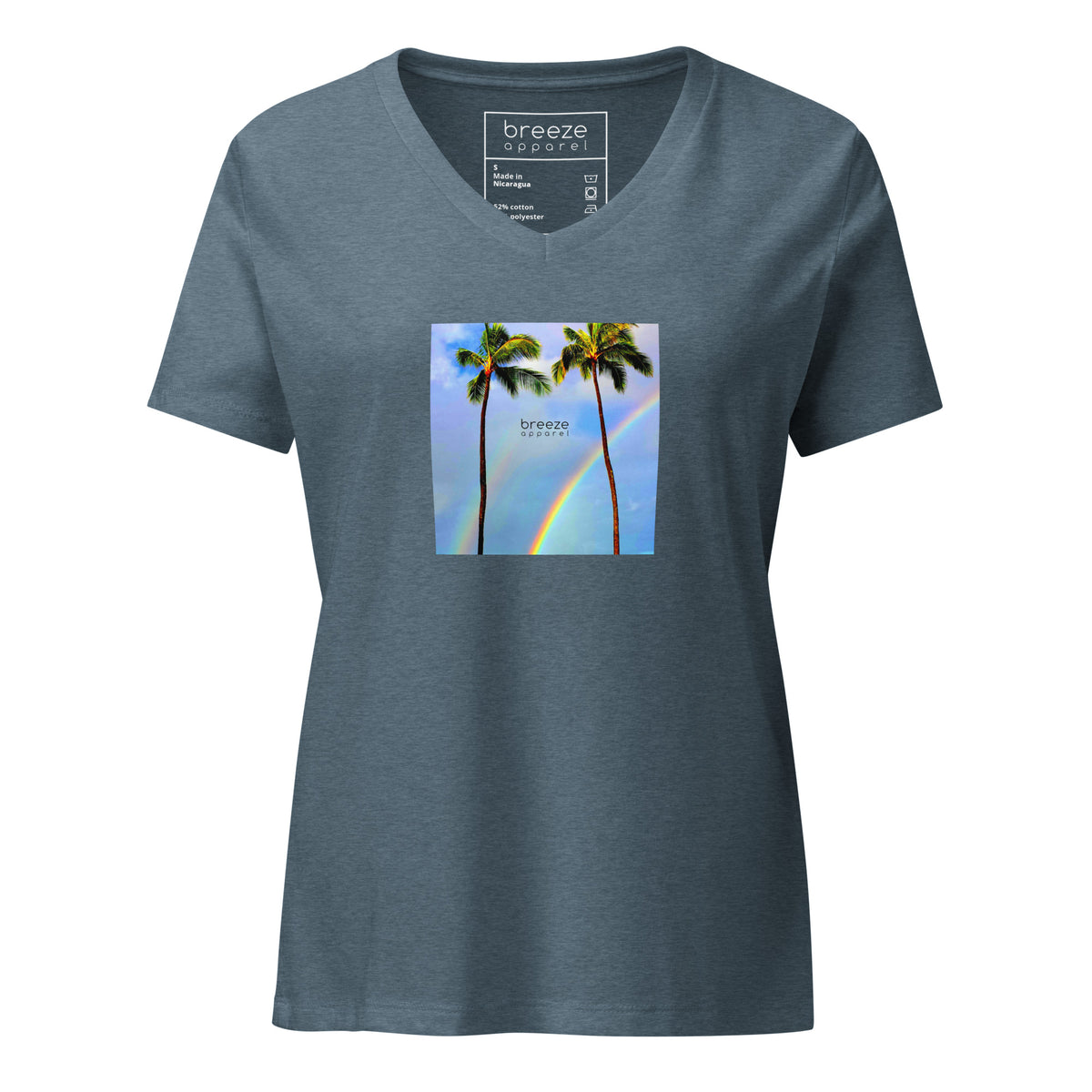 Heather-slate-blue v-neck t-shirt with a graphic of palm trees, rainbow, and a clear blue sky in the background. A small, black 'breeze apparel' logo is between the trees. 