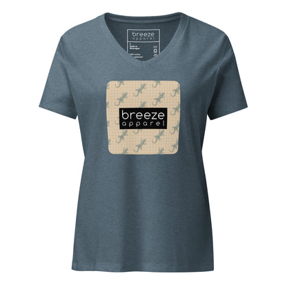 Blue t-shirt with square over chest that contains pattern of green geckos set on beige background, overlaid with black, rectangular logo with white lettering.