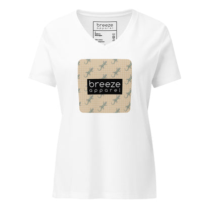 White t-shirt with square over chest that contains pattern of green geckos set on beige background, overlaid with black, rectangular logo with white lettering.